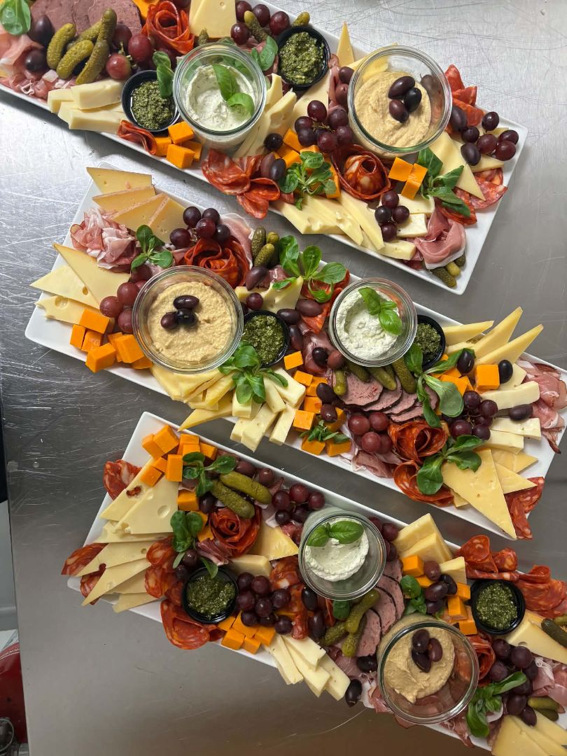 Tre tapasfade fra Spiis med ost, spegepølse, serranoskinke, hummus, pesto, oliven, druer og friske krydderurter